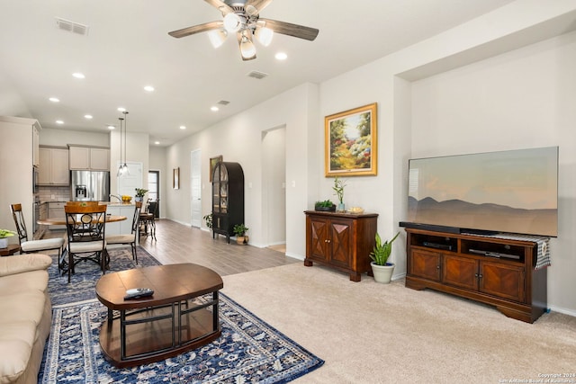 carpeted living room featuring ceiling fan