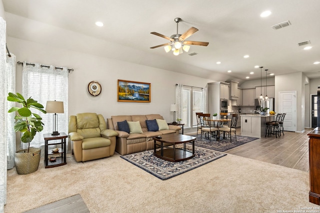 living room featuring light hardwood / wood-style floors, ceiling fan, and a wealth of natural light