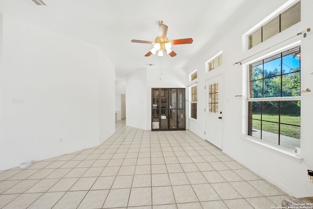 interior space with ceiling fan, light tile patterned floors, and vaulted ceiling