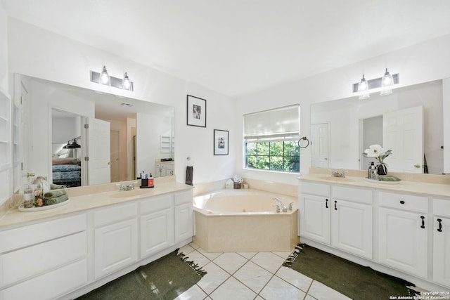 bathroom with tile patterned flooring, a bathtub, and vanity