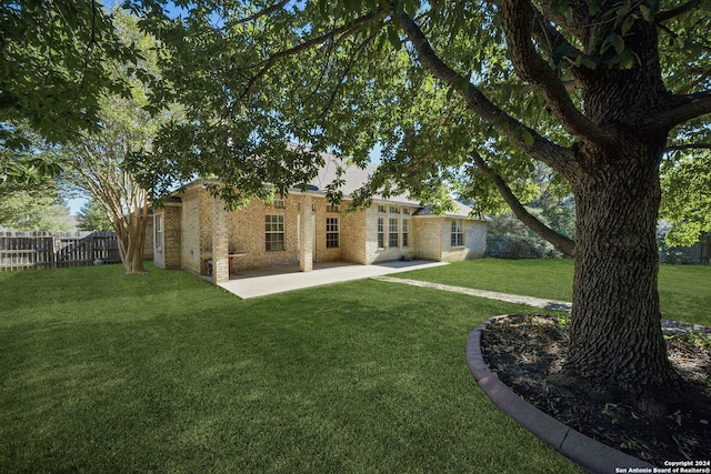 back of property featuring a patio and a lawn