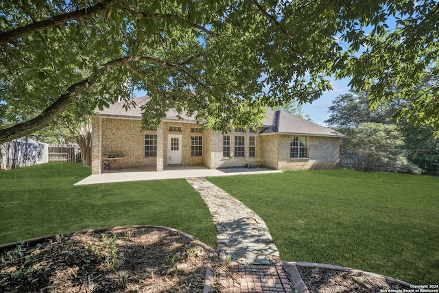 back of property with a patio area and a yard