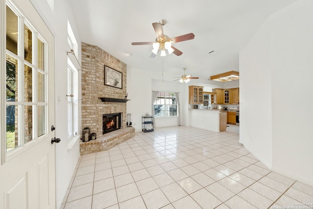 unfurnished living room featuring ceiling fan, a fireplace, and light tile patterned floors