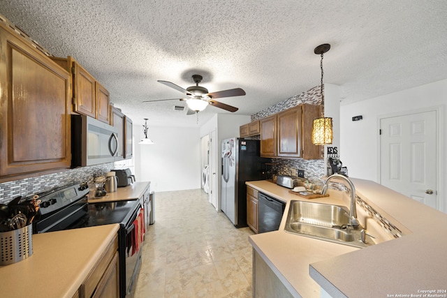 kitchen with hanging light fixtures, sink, appliances with stainless steel finishes, a textured ceiling, and tasteful backsplash