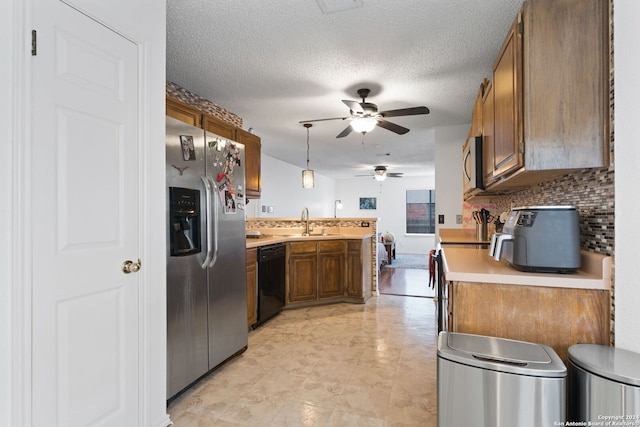 kitchen with hanging light fixtures, stainless steel appliances, backsplash, sink, and a textured ceiling