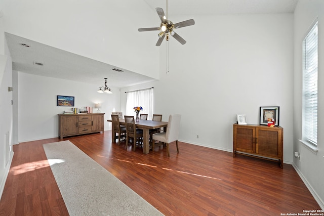 dining space featuring high vaulted ceiling, dark hardwood / wood-style flooring, and ceiling fan with notable chandelier