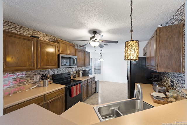 kitchen featuring backsplash, a textured ceiling, sink, pendant lighting, and stainless steel appliances