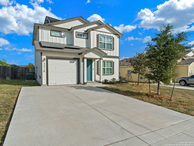 view of front facade with cooling unit, a front yard, and a garage