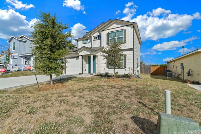 view of front of home with a front yard, central AC unit, and a garage