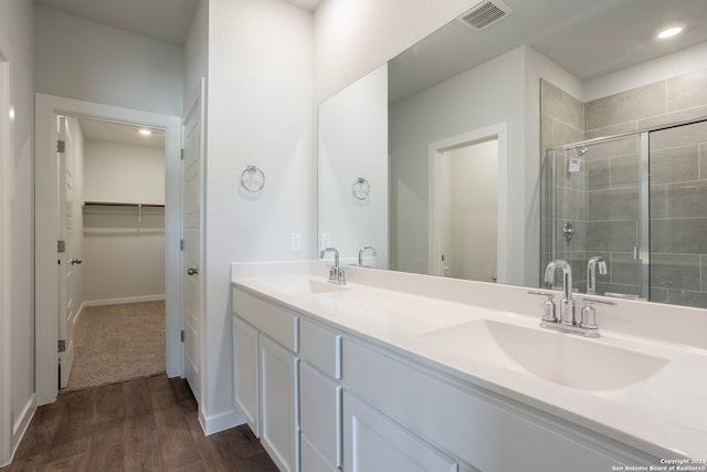 bathroom with a shower with door, wood-type flooring, and vanity