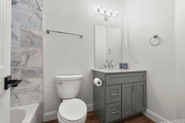 full bathroom featuring vanity, tiled shower / bath, hardwood / wood-style floors, and toilet