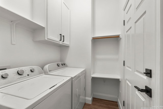 laundry area featuring cabinets, washer and clothes dryer, and dark hardwood / wood-style flooring