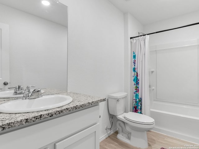 full bathroom with toilet, hardwood / wood-style floors, vanity, and shower / bath combo