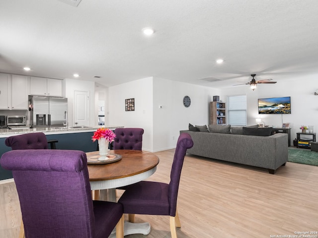 dining space featuring ceiling fan and light hardwood / wood-style flooring