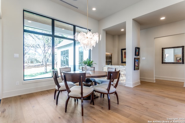 dining area featuring a notable chandelier and light wood-type flooring