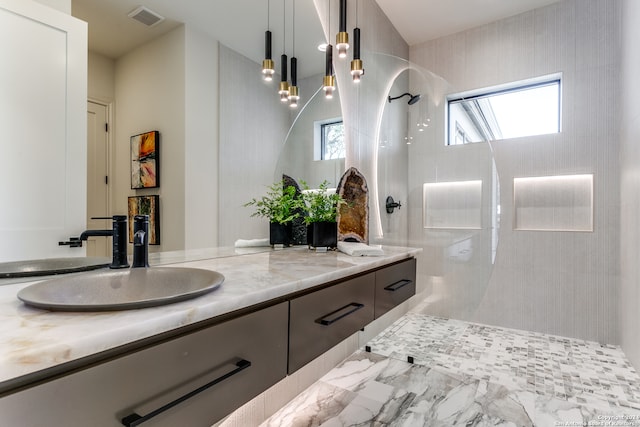 bathroom with vanity and a tile shower