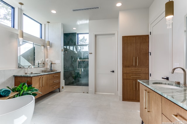 bathroom featuring vanity, a healthy amount of sunlight, and shower with separate bathtub