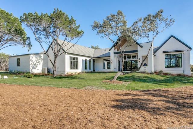 rear view of house featuring a yard