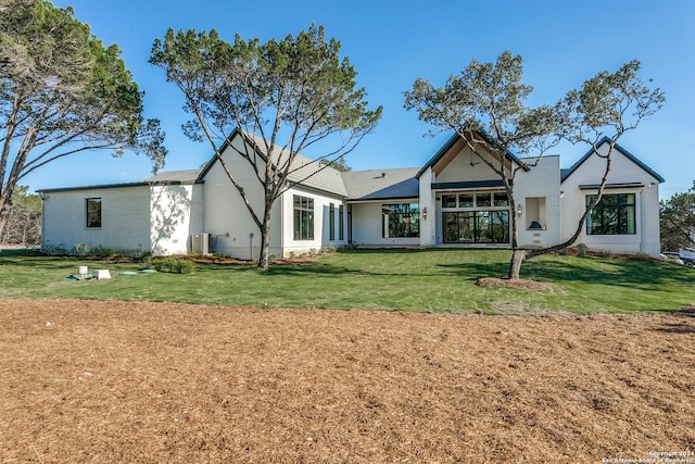 rear view of property featuring a lawn