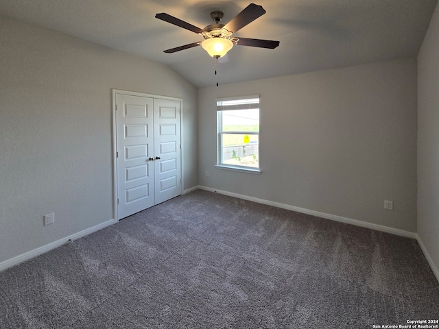 unfurnished bedroom featuring carpet flooring, ceiling fan, vaulted ceiling, and a closet