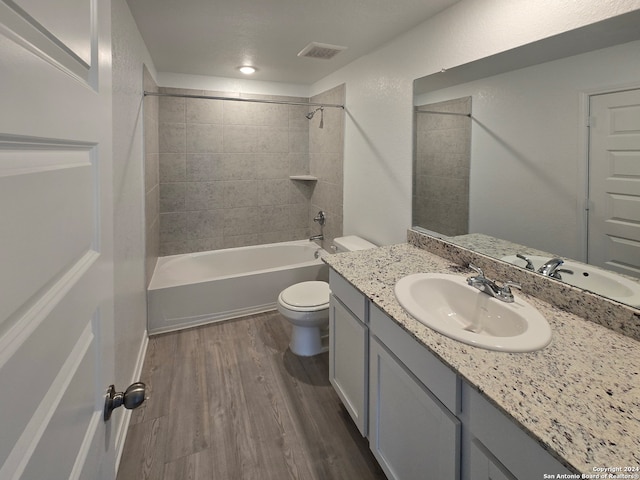 full bathroom with wood-type flooring, vanity, toilet, and tiled shower / bath combo