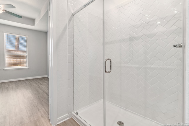 bathroom with an enclosed shower, hardwood / wood-style flooring, and ceiling fan