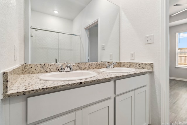 bathroom featuring wood-type flooring, vanity, and a shower with shower door