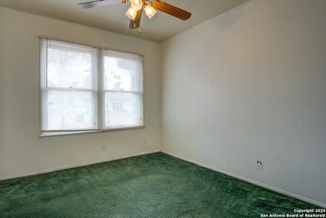 spare room with ceiling fan and dark carpet