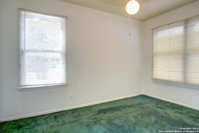 carpeted empty room featuring plenty of natural light and ceiling fan