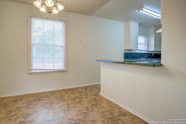 kitchen featuring sink, a wealth of natural light, and an inviting chandelier