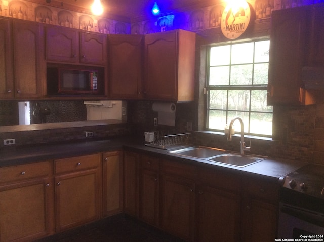 kitchen featuring backsplash, sink, and stove