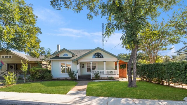 214 Loretta Pl, San Antonio, TX 78210 - bungalow-style home with a porch, a front lawn, and a chimney