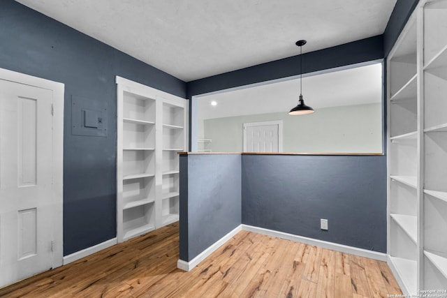 interior space with electric panel and hardwood / wood-style flooring