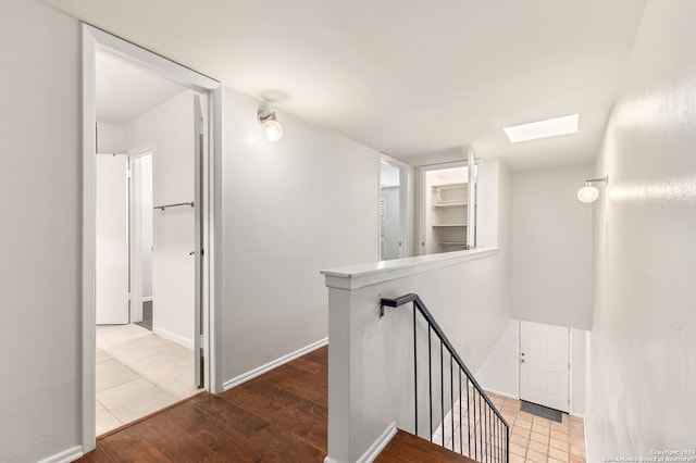 corridor featuring wood-type flooring and a skylight