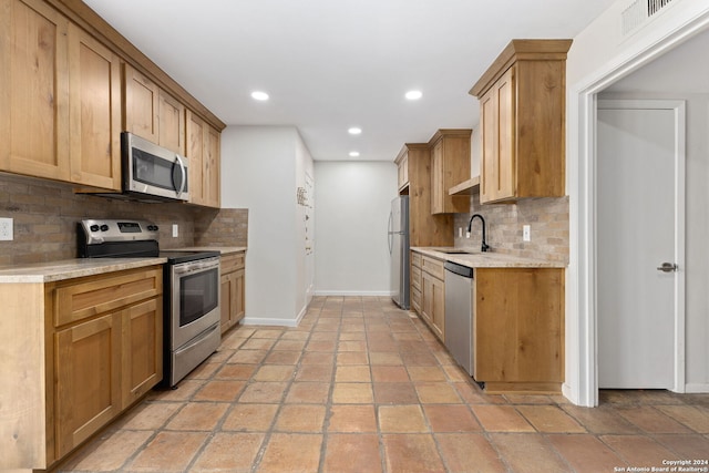 kitchen with decorative backsplash, stainless steel appliances, and sink