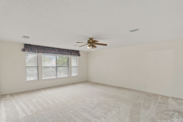 spare room with light carpet, a textured ceiling, and ceiling fan