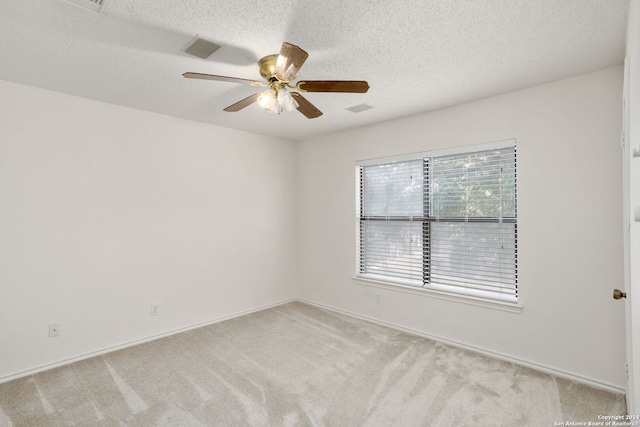 carpeted spare room with ceiling fan and a textured ceiling