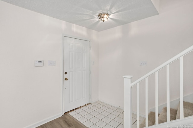 entrance foyer with light hardwood / wood-style floors and a textured ceiling