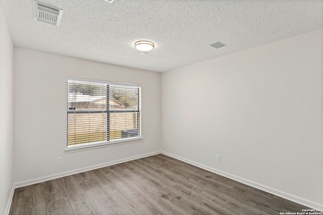 unfurnished room featuring a textured ceiling and hardwood / wood-style flooring