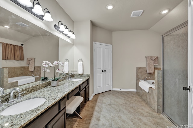 bathroom with vanity, tile patterned floors, vaulted ceiling, and tiled bath