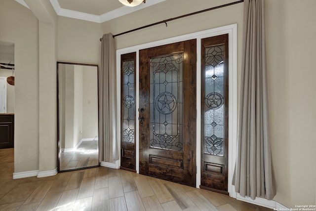 foyer with crown molding and light hardwood / wood-style floors