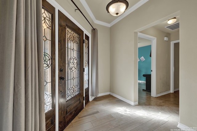 foyer featuring a wealth of natural light, ornamental molding, and light wood-type flooring