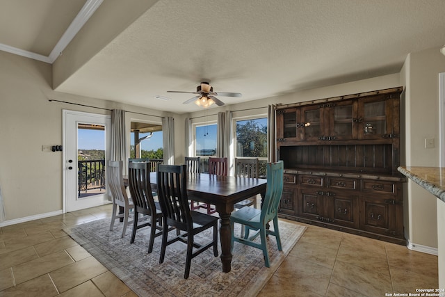 dining space featuring crown molding, a textured ceiling, light tile patterned floors, and ceiling fan