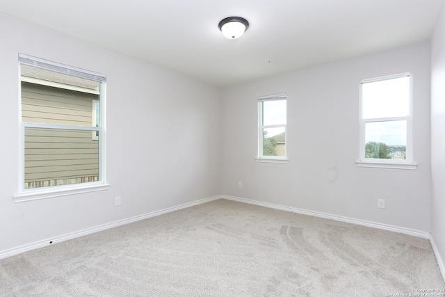 spare room featuring light carpet