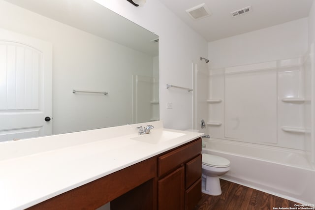 full bathroom with vanity, toilet, hardwood / wood-style flooring, and washtub / shower combination