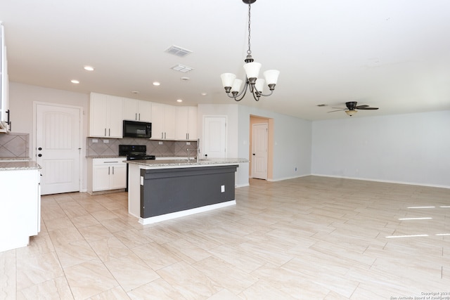 kitchen with a kitchen island with sink, black appliances, decorative light fixtures, white cabinets, and light stone counters