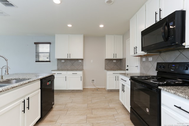 kitchen with tasteful backsplash, black appliances, sink, white cabinetry, and light stone counters