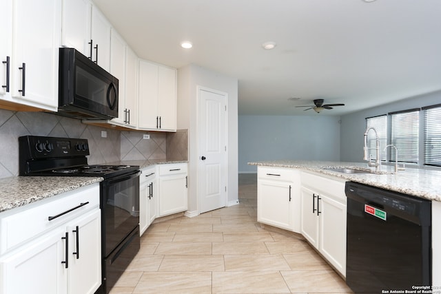 kitchen featuring white cabinets, light stone countertops, black appliances, and sink