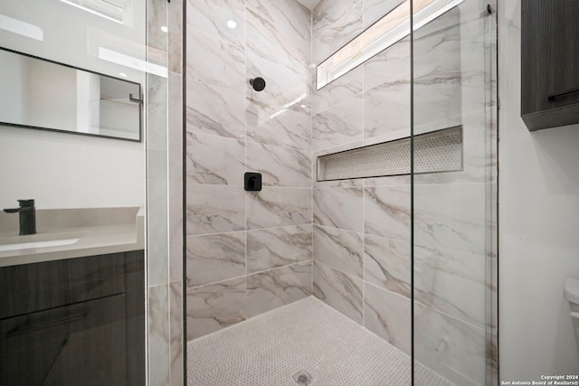 bathroom with vanity and a tile shower