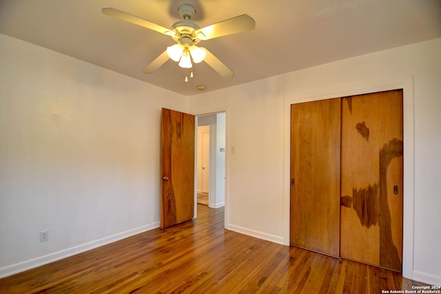 unfurnished bedroom featuring hardwood / wood-style floors, a closet, and ceiling fan